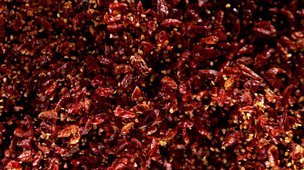 Freeze motion of flying chilli peppers on black background.