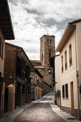 Fototapeta na wymiar Cobbled street with church in the background (Sierra de Madrid, Buitrago del Lozoya, Spain)