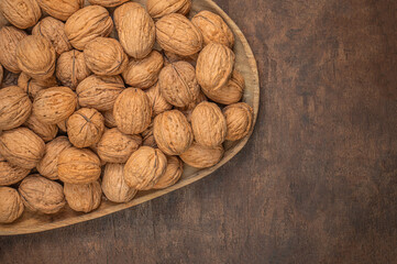 Walnuts on dark vintage table. Walnuts kernels with green leaves. Copyspace.