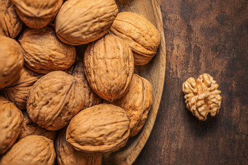 Walnuts on dark vintage table. Walnuts kernels with green leaves. Copyspace.