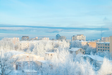 City view in winter. Houses and trees in snow. Beginning of winter season.