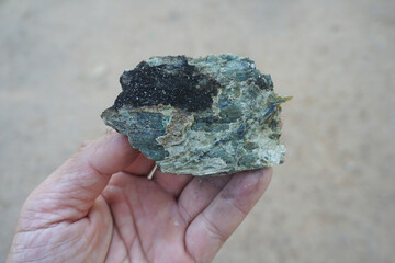 Raw of Antigorite serpentine mineral in the hand of a geologist. 