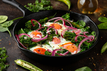 Green shakshuka with golden yolk eggs, kale, spinach and tender broccoli served with pickled onions and chilli flakes