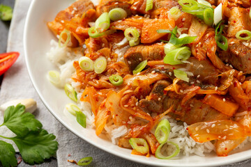 Korean Stir Fried pork belly kimchi with rice and spring onion. Asian food style