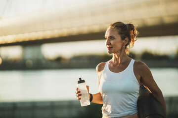 Woman With Water Bottle Before Training Near The River