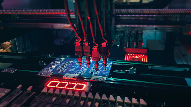 Pick and Place robot machine: SMD Assembly of electronic components on a motherboard by an automated Pick and Place robot. Technology for SMD assemblage of chips with artificial intelligence.