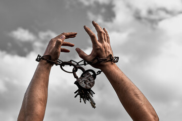 Male hands chained close-up. Chain with a lock on the hands. Addicted person. The prisoner is a man.