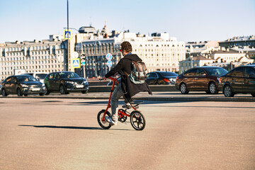 Obraz premium A man rides a bicycle through the city. A cyclist rides a bike among cars
