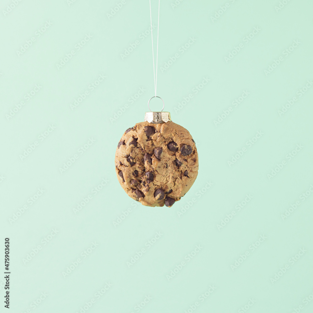 Wall mural creative arrangement made of a christmas cookie and bauble decoration on a pastel green background. 