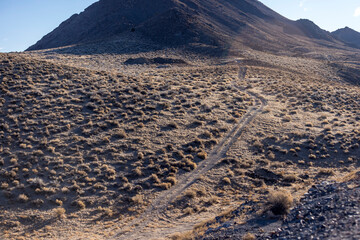 Four wheel drive road climbs from a canyon up into the hills in the desert