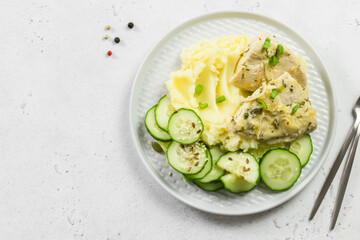 Classic homemade mashed potatoes, cucumber salad, steamed chicken. Top view, copy space.