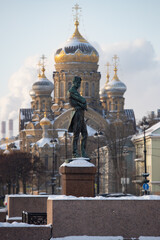 monument to the navigator Kruzenshtern in front of the Cathedral of Lieutenant Schmidt on a clear winter frosty day, golden dome and cross of church