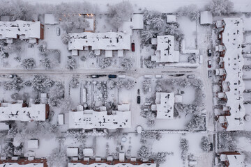 Top view of city covered by snow. Townhouses after snowfall. Drone view