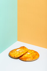 Uzbek national food Tandyr bread Lepeshka with cheese on blue background minimalistic style