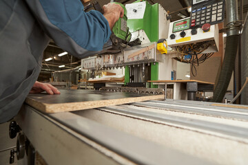 Competent male joiner using electric machine at work