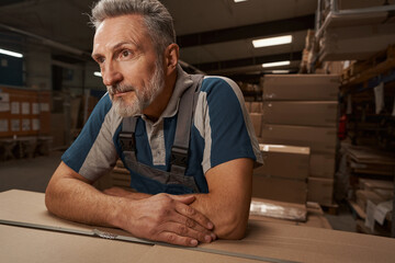 Kind grey-haired man being deep in his thoughts
