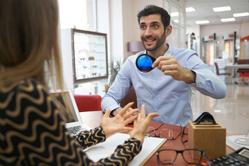 Shocked customer holding optical loupe with blue filling