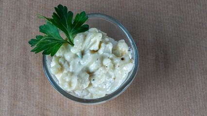 Top view of Home made tartar sauce in dish on parchment. Bowl of fresh garlic dip.