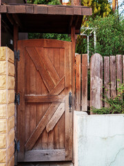 An old wooden door painted brown under a visor