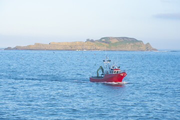 Naklejka premium Fishing boat entering Bermeo with the island of Izaro in the background, Euskadi