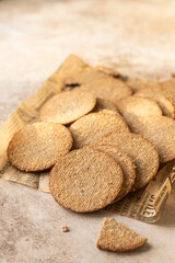 Delicious crackers with sesame and flax seeds on brown background. Healthy snack.