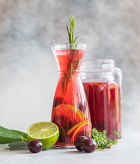 Cocktail or lemonade with cherries and lime, grey stone background. Mocktail. Cold summer drink.