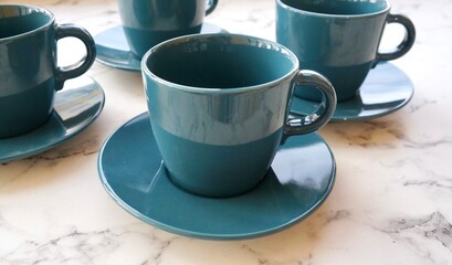 A tea mug with a sea-green saucer, a set of dishes for tea drinking