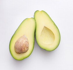 Ripe avocado on a white background, halves of avocado.