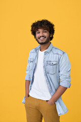 Smiling young curly indian cool positive guy standing isolated on yellow background. Happy ethnic...