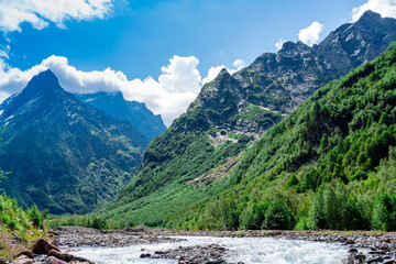 View of the mountain river in the gorge, North Ossetia, Russia. Impenetrable rocks, majestic sun, mountains and forests.
