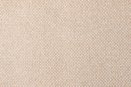 The texture of the fabric. Beige jacquard close-up. Soft expensive fabric for furniture, curtains, pillows and car upholstery. Background. A place to copy.