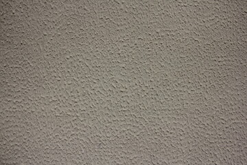 An old, gray painted plastered concrete stone wall with a small smudges background texture