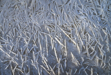 Natural natural ice background. Abstract patterns on ice illuminated by the sun. Snow and frost. Space to insert text.