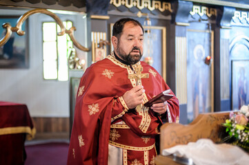 Religious priest holds holy Christian cross during religious chuch ceremony