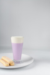 Glass of purple latte and savoiardi, Lady finger biscuits and a latte