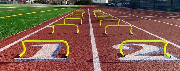 Low angle view of yellow mini hurdles set up on a track for running the wicket drill over