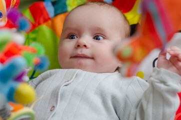 Baby looks at hanging rattles, close-up