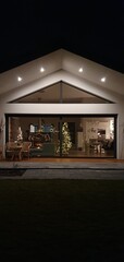 Obraz premium Dom parterowy w ogrodzie, oświetlenie elewacji, duże okna w domu