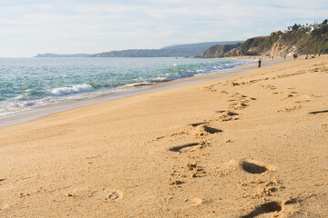 Footsteps on sand at empty beach on sunny day in Algarrobo, Chile. Hardship, gone, sadness concepts