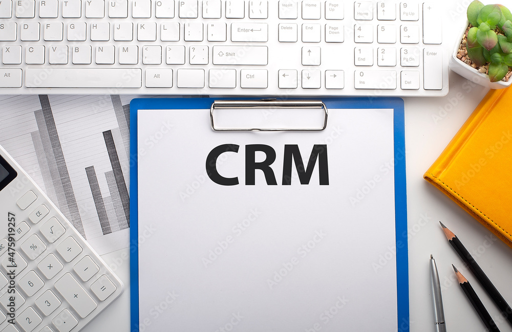 Poster crm written on paper with keyboard, chart, calculator and notebook