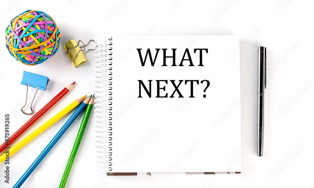 Poster notebook ,pencils,pen and rubber band with text what next on the white background
