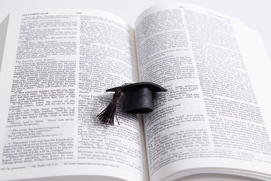 Graduate cap on the pages of the holy bible. Spiritual education concept