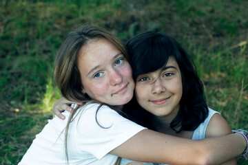 Fototapeta premium Two teen girl sister sitting in the summer park.