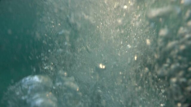 The camera is immersed under the water and over the sea in the drowning sea. Beautiful light refracts on the surface of the waves, diving, snorkeling.