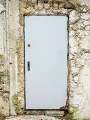 Iron gray door without a handle in a concrete wall