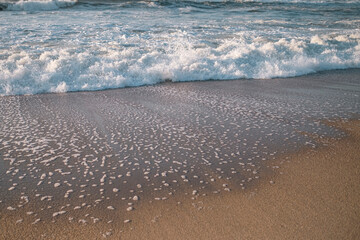 Fototapeta na wymiar The foamy surf on Atlantic beach.