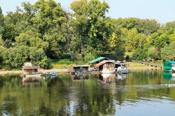 Fototapeta na wymiar Houses on the water, houseboats, moored to the shore on the Sava river 