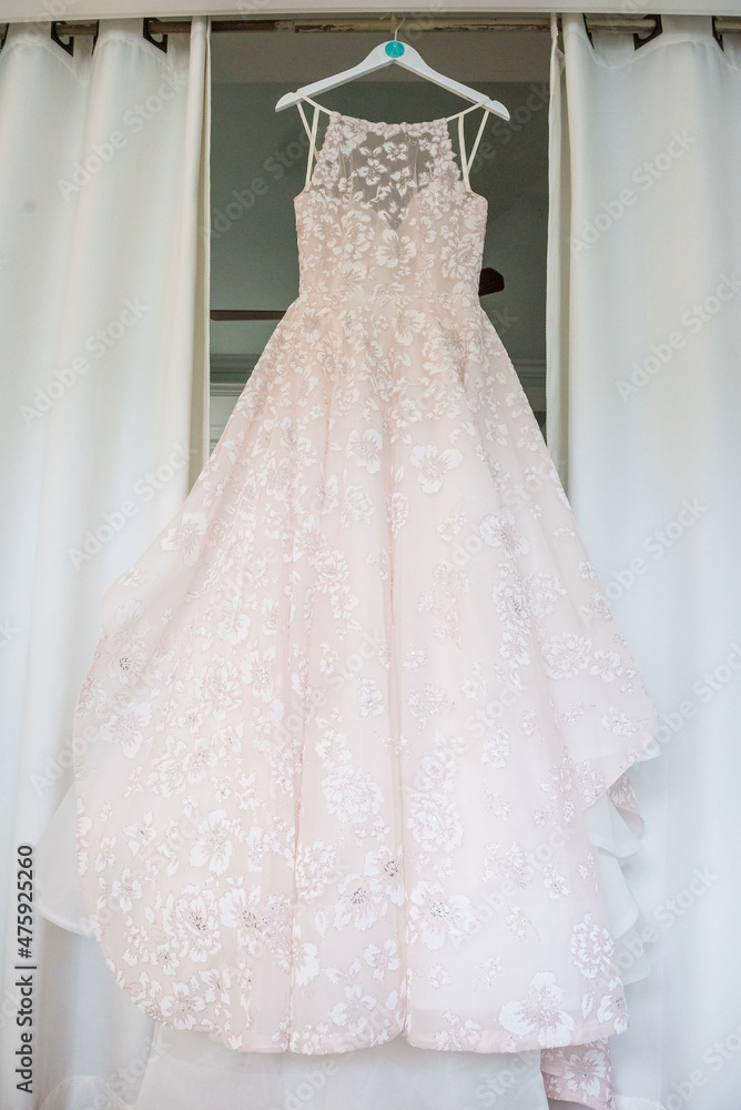 Poster Vertical shot of a bridal evening gown hanging in the room