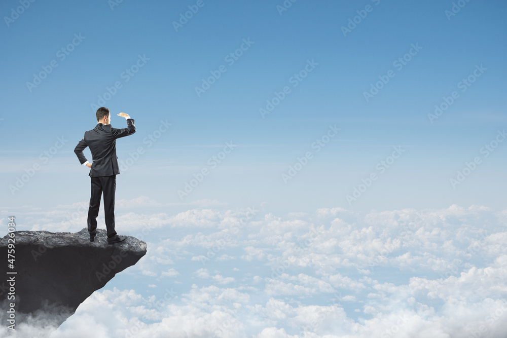 Poster abstract image of businessman looking into the distance while standing on edge of cliff, mock up pla