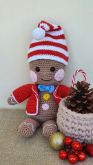 Fototapeta premium Cute handmade toy, colorful crocheted doll and Christmas ornaments on the table.